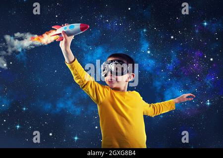 Kind spielt mit einer kleinen Rakete. Konzept der Phantasie Stockfoto