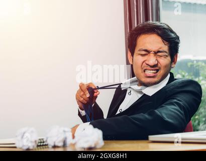 Junge asiatische Geschäftsmann Manager frustriert er hat müde nach Arbeiten Sie lange Stockfoto