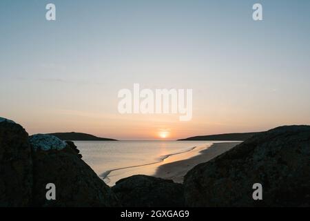 Sonnenuntergang mit Felsen im Vordergrund, am Strand von Big Sand, Gairloch, Schottland. Stockfoto