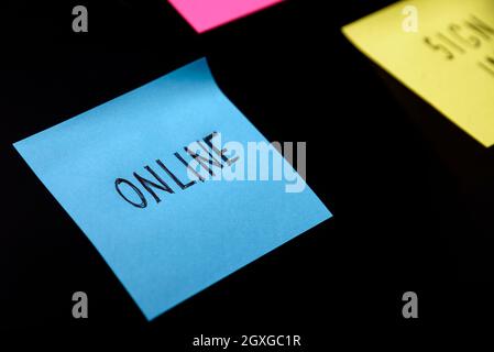 Farbenfrohe Haftnotizen auf schwarzen Brettschinden. Online geschriebener Aufkleber auf der Zirbeldrüse. Digitales und Online-Geschäftskonzept. Stockfoto