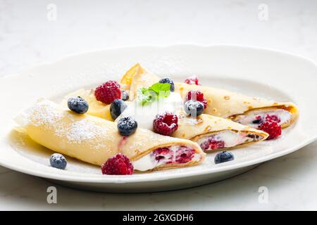 Pankaces gefüllt mit Heidelbeeren, Himbeeren und Rahm Stockfoto