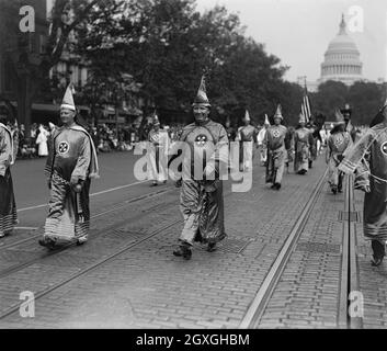 Vintage-Foto vom 13. September 1926, das in Roben gekleidete Mitglieder des Ku Klux Klan auf der Pennsylvania Avenue in Washington D.C. mit der Flagge der Stars und Stripes und der Kuppel des Capitols im Hintergrund zeigt. An der Spitze der Parade steht Hiram Wesley Evans, Großassistent des KKK. Evans hatte die Entführung und Folter eines schwarzen Mannes angeführt, während er den Dallas Klan anführte Stockfoto