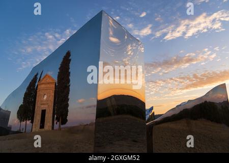 Die alte Kirche von Vitaleta spiegelt sich im Abbracio di luce Denkmal von Helidon Xhixha bei Sonnenuntergang in San Quirico d'Orcia, in der Nähe von Pienza, Toskana, Italien Stockfoto