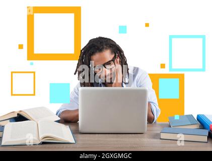 Der Student studiert mit seinem Laptop und einem Schreibtisch voller Bücher Stockfoto