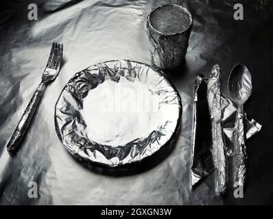 Home Teller, Geschirr und ein Glas mit Aluminiumfolie bedeckt Stockfoto