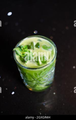 matcha Cocktail oder Tee oder Latte mit Eis und Minze isoliert auf schwarzem Hintergrund. Moderne Getränke. Trendiger Cocktail. Stockfoto