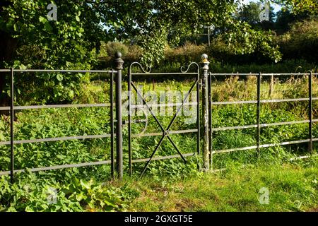 Großbritannien, England, Oxfordshire, Banbury, Horley, Dekoratives Eisentor im Zaun in der Nähe der Alten Schmiede Stockfoto