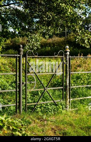 Großbritannien, England, Oxfordshire, Banbury, Horley, Dekoratives Eisentor im Zaun in der Nähe der Alten Schmiede Stockfoto