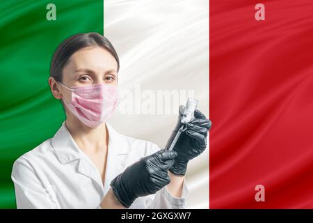 Die Ärztin bereitet die Impfung vor dem Hintergrund der italienischen Flagge vor. Impfkonzept Italien. Stockfoto