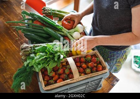 Frau packt ihre Lebensmittel in der Küche zu Hause aus Stockfoto
