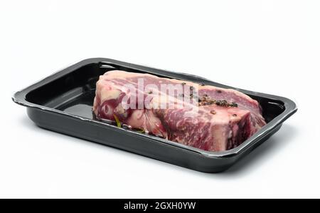 Rohes New Yorker Rindersteak wird in einem Kunststoffbehälter verpackt und vakuumversiegelt. Langfristige Lagerung von Striploin-Fleisch Stockfoto