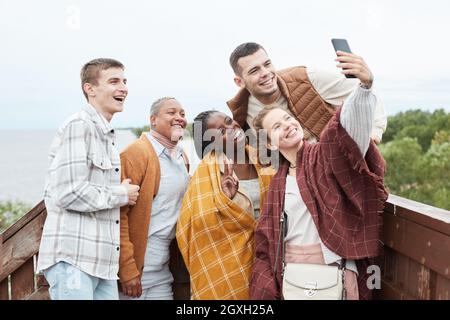 Diverse Gruppe junger Freunde, die während der Wanderung Selfie am Aussichtspunkt machen, Platz kopieren Stockfoto