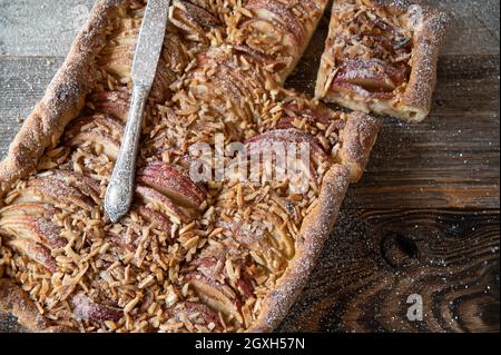 Rustikaler Apfelkuchen oder Kuchen mit Mandeln, gebacken mit Hefeteig und frischem Obst aus dem Garten Stockfoto