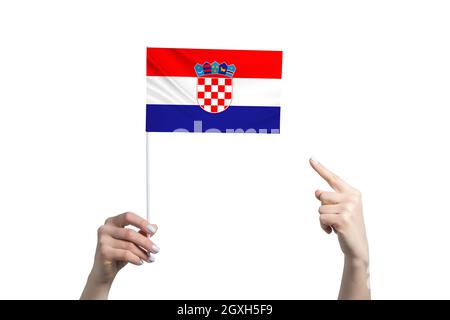 Eine schöne weibliche Hand hält eine kroatische Flagge, auf der sie den Finger ihrer anderen Hand zeigt, isoliert auf weißem Hintergrund. Stockfoto