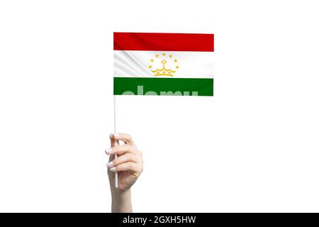 Schöne weibliche Hand hält Tadschikistan Flagge, isoliert auf weißem Hintergrund. Stockfoto