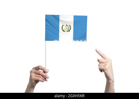 Eine schöne weibliche Hand hält eine Guatemala-Flagge, auf der sie den Finger ihrer anderen Hand zeigt, isoliert auf weißem Hintergrund. Stockfoto