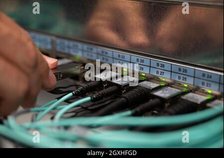 Stuttgart, Deutschland. Oktober 2021. Ein Mitarbeiter des High Performance Computing Center HLRS hält ein Glasfaserkabel. Quelle: Marijan Murat/dpa/Alamy Live News Stockfoto