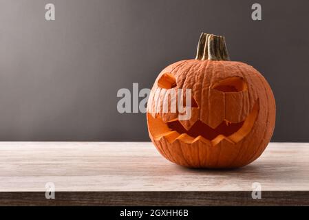 Geschnitzter halloween Kürbis auf Holztisch schwarz isoliert Hintergrund. Vorderansicht. Horizontale Zusammensetzung. Stockfoto
