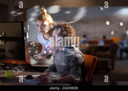 Zwei junge Designer arbeiten an einem neuen Projekt in der Nachtgottesdienst mit Hilfe moderner Technologie Stockfoto
