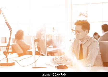 Jungunternehmer-Programmierer in großes helles Büro bei der Arbeit mit computer Stockfoto