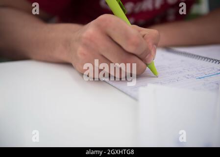 Nahaufnahme eines Studenten Hand unterstreichen ein Dokument auf einem Schreibtisch in der Schule Klassenzimmer Stockfoto