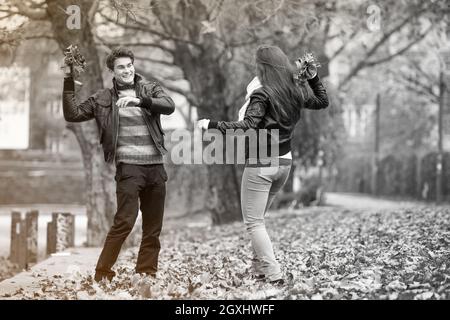 Glückliches junges Paar im Herbst-Park. Fallen. Gelbe Bäume und Blätter. Mann und Frau vor Lachen. Freiheit-Konzept. Stockfoto