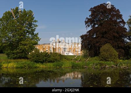 Blick über den Serpentine See im Waverley Abbey House, in der Nähe von Farnham, Surrey, England, Großbritannien, Mit dem Haus sichtbar zwischen den Bäumen Stockfoto