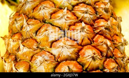 Nahaufnahme der schmackhaften reifen Ananas, halbiert. Abstrakter Hintergrund exotischer Früchte. Stockfoto