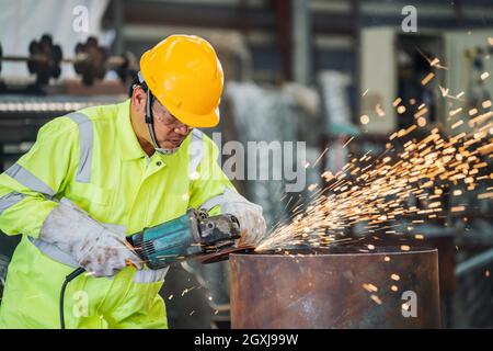 Eine elektrische Schleifscheibe auf Stahlkonstruktion in der Fabrik Stockfoto