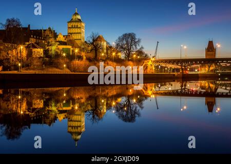 Gotisches Burgtor spiegelt sich im Wasser des Elbe-Lübeck-Kanals, mittelalterliches Stadttor des Hanseatischen Lübecks bei Nacht, Schleswig-Holstein, Deutschland Stockfoto