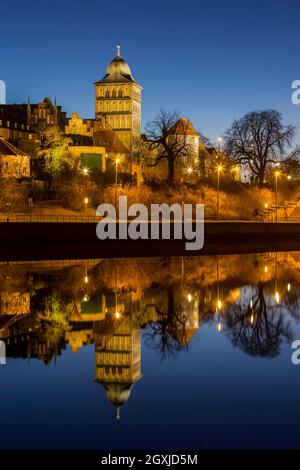 Gotisches Burgtor spiegelt sich im Wasser des Elbe-Lübeck-Kanals, mittelalterliches Stadttor des Hanseatischen Lübecks bei Nacht, Schleswig-Holstein, Deutschland Stockfoto