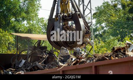 Hydraulische Klauen heben und zerstören Metall auf Schrottplatz Stockfoto