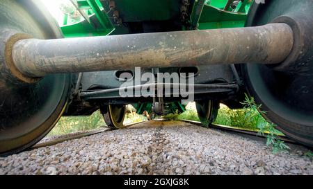 Blick vom Boden auf große Metallbahn Axxle auf der Eisenbahn Stockfoto