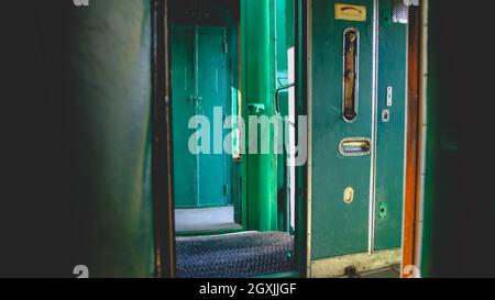 Getöntes Foto der offenen Türen im Korridor des alten Dampfexpress Trians Stockfoto