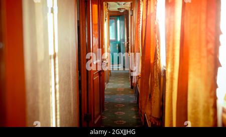 Innenausstattung eines Retro-Dampfeisenbahnwagens mit Holztüren und Teppichen auf dem Boden Stockfoto