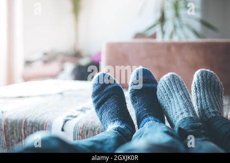 Füße mit wollsocken im Winter: Paar ist auf dem Sofa entspannen Stockfoto