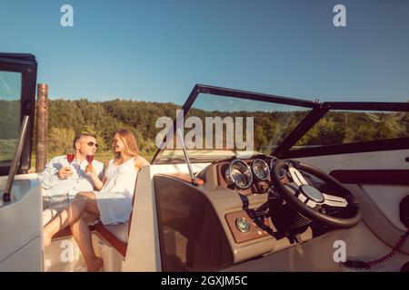 Frau und Mann entspannen sich im Sommer auf ihrer Flussyacht Stockfoto