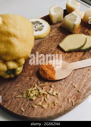 Zutaten für Ingwer, Zitrone und Kurkuma auf einem Schneidebrett Stockfoto