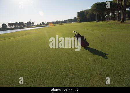 Golfbag mit Club und Ball vorne am wunderschönen Sonnenaufgang auf Kurs Stockfoto