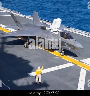 Ein U.S. Marine Corps F-35B Lightning II Stealth-Kampfjet mit Marine Fighter Attack Squadron 242 führt während gemeinsamer Einsätze am 3. Oktober 2021 vor der japanischen Küste eine vertikale Landung auf dem Flugdeck des japanischen Hubschrauberflugzeuges JS Izumo durch. Die Landung ist die erste F-35B Lightning II-Kampfflugzeug-Operation an Bord eines japanischen Schiffes. Stockfoto