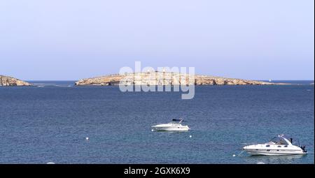 Malta - St. Paul’s Bay im Nordwesten Maltas und eine kleine, unbewohnte St. Paul's Island mit der Statue des heiligen im Hintergrund. Stockfoto