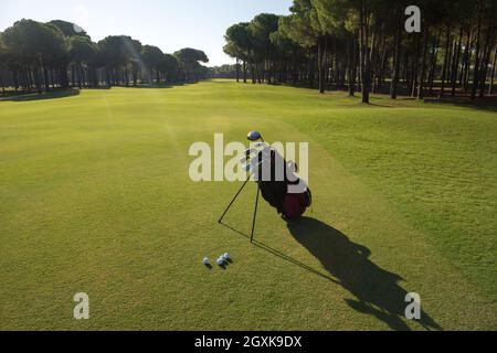 Golfbag mit Club und Ball vorne am wunderschönen Sonnenaufgang auf Kurs Stockfoto