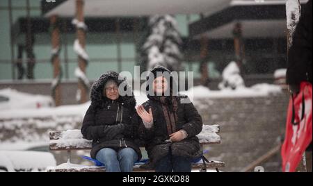 Porträt von zwei Reife Frau sitzen im Park am schönen Wintertag mit frischem Schnee Stockfoto