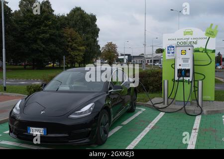 Ostrava, Tschechische Republik - 23. September 2021. Eine statische Aufnahme eines soliden schwarzen Tesla Model 3 Dual-Motors, der beim LIDL Supermarkt DC Charging sta geladen wurde Stockfoto