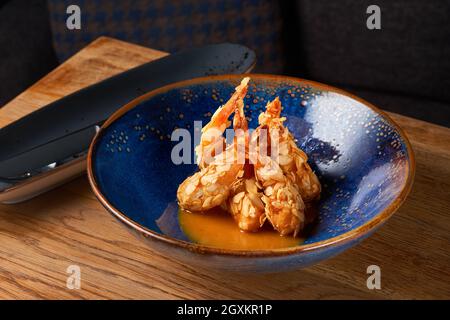 Scharfe, gebratene Garnelen in einer Schüssel. Knusprige Garnelen in, Chili Sauce auf dem Tisch, serviert in einem Restaurant, Menü Food-Konzept. Stockfoto