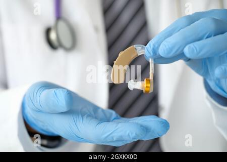 Arzt Otorhinolaryngologe, der Hörgeräte in der Nähe in den Händen hält Stockfoto