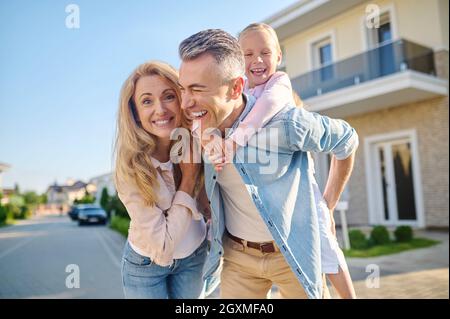 Glücklicher Mann mit Mädchen und Frau, die auf der Straße gehen Stockfoto