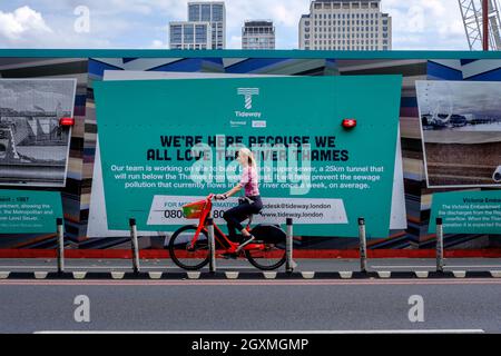 Der Radfahrer kommt am Victoria Embankment, London, Großbritannien, an einer Baustelle für den Londoner Super-Kanal unterhalb der Themse vorbei Stockfoto