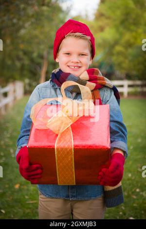 Hübscher Junge Urlaub Kleidung Weihnachtsgeschenk draußen halten. Stockfoto