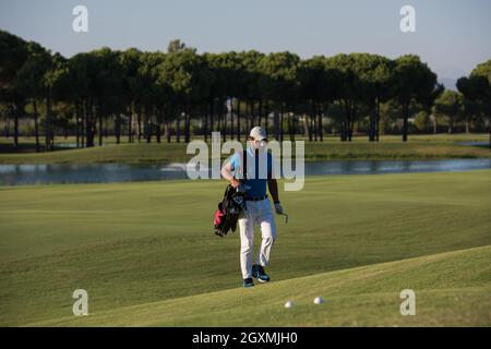 schöne orientalische Golfer Tragetasche und zu Fuß zum nächsten Loch am Golfplatz Stockfoto